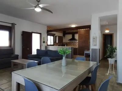a kitchen and living room with a table and chairs at Casa Ramos in Conil de la Frontera