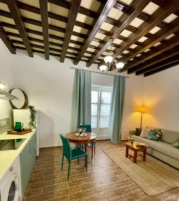 a living room with a table and a couch at GINVA - Casa palacio La Templanza in El Puerto de Santa María
