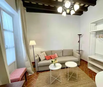 a living room with a couch and two tables at GINVA - Casa palacio La Templanza in El Puerto de Santa María
