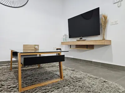 a living room with a desk and a tv on a wall at El Anfitrión - Palacio Argüeso in Sanlúcar de Barrameda