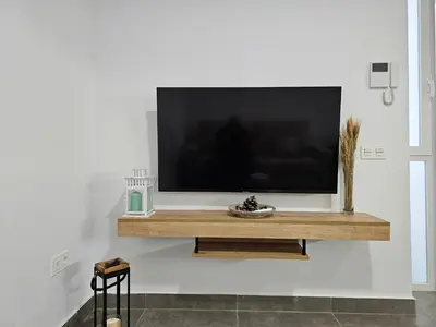a flat screen tv on a white wall at El Anfitrión - Palacio Argüeso in Sanlúcar de Barrameda