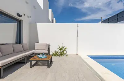 a living room with a couch and a table next to a pool at Casa Pedro Luis in Conil de la Frontera
