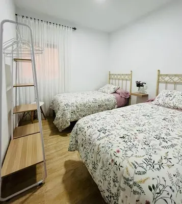 a bedroom with two beds and a ladder at Apartamento Merykuki in Sanlúcar de Barrameda
