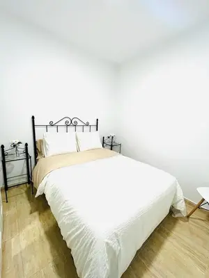 a bedroom with a large white bed with white sheets at Apartamento Merykuki in Sanlúcar de Barrameda