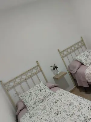 a bedroom with two beds with pink sheets at Apartamento Merykuki in Sanlúcar de Barrameda
