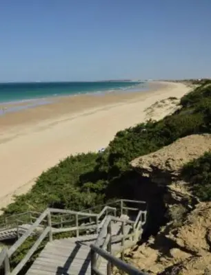 a wooden staircase leading to a sandy beach at Villa La Vida in Chiclana de la Frontera