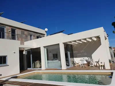 a white house with a swimming pool and a patio at Villa La Vida in Chiclana de la Frontera