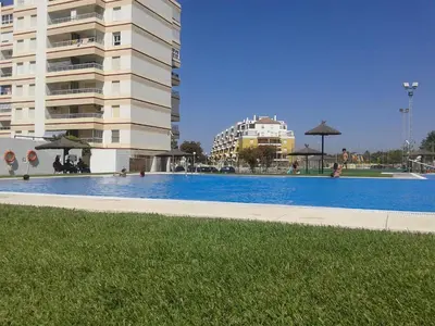 a large swimming pool in front of a building at Apartamento Las Olas de Valdelagrana in El Puerto de Santa María