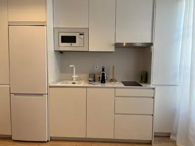 a kitchen with white cabinets and a microwave at Hidden Gem. Capuchinos Boutique Homes in Cádiz