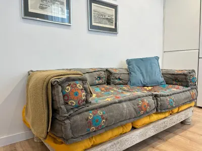 a couch is sitting against a wall at Hidden Gem. Capuchinos Boutique Homes in Cádiz