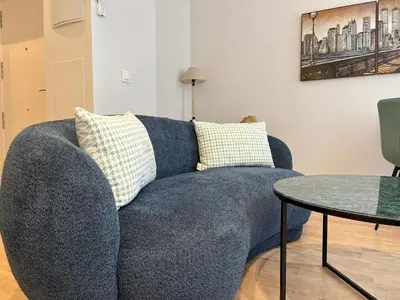 a blue couch in a living room with a table at Hidden Gem. Capuchinos Boutique Homes in Cádiz