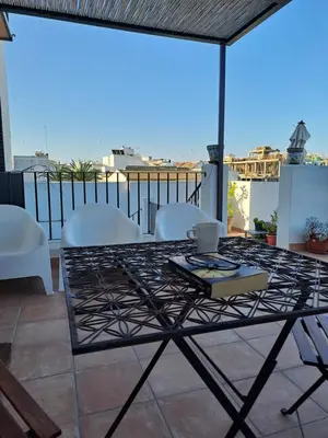 a table and chairs on a balcony with a view at La Carabela, Elcano in Sanlúcar de Barrameda