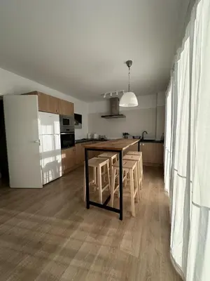 a kitchen with a table and chairs and a refrigerator at La Carabela, Elcano in Sanlúcar de Barrameda