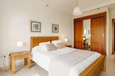 a bedroom with a large white bed and a table at Country Home in Arcos de la Frontera