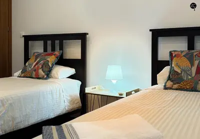 a mirror with a couch and two stools in a room at Rym House Grupo AC Gestion in Cádiz