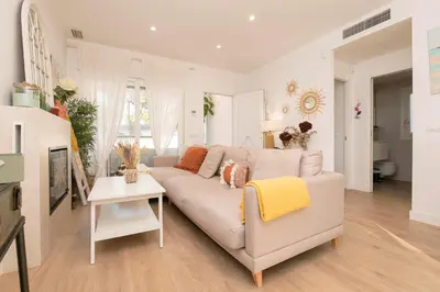 a white living room with a couch and a table at La Perla Costera in Chiclana de la Frontera