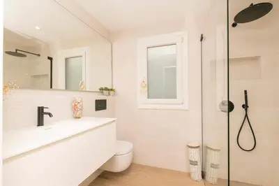a white bathroom with a sink and a shower at La Perla Costera in Chiclana de la Frontera