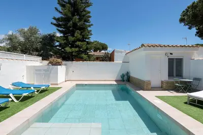 a swimming pool in the backyard of a house at La Perla Costera in Chiclana de la Frontera