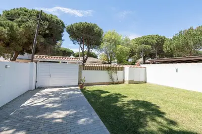a backyard with a white fence and a grass yard at La Perla Costera in Chiclana de la Frontera