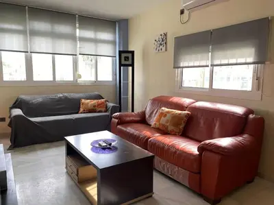 a living room with a leather couch and a table at APARTAMENTO SALINAS VALDELAGRANA - WiFi, Playa, Piscina in El Puerto de Santa María
