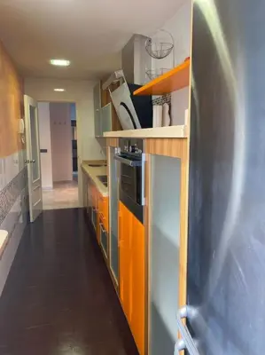 a kitchen with orange and gray cabinets and a kitchen at APARTAMENTO SALINAS VALDELAGRANA - WiFi, Playa, Piscina in El Puerto de Santa María