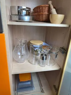 a cabinet with some glass items on a shelf at APARTAMENTO SALINAS VALDELAGRANA - WiFi, Playa, Piscina in El Puerto de Santa María