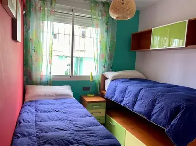 a bedroom with two beds and a window at APARTAMENTO SALINAS VALDELAGRANA - WiFi, Playa, Piscina in El Puerto de Santa María