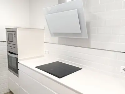 a white kitchen with a stove and a microwave at Ático Sol in San Fernando