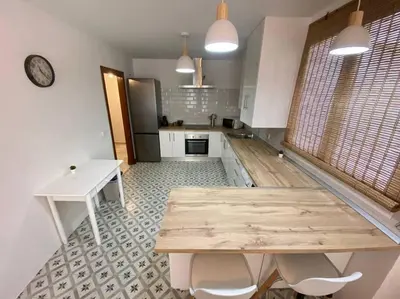 a large kitchen with a wooden table and chairs at Apartamento en centro con garaje in Sanlúcar de Barrameda
