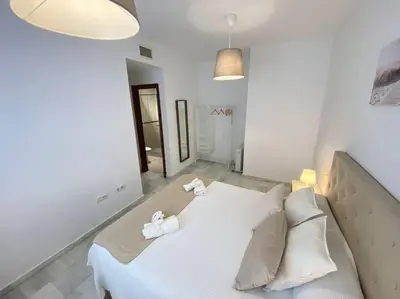 a large white bed in a white room with two pillows at Apartamento en centro con garaje in Sanlúcar de Barrameda