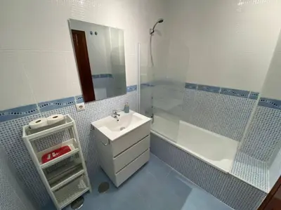 a blue and white bathroom with a sink and a tub at Apartamento en centro con garaje in Sanlúcar de Barrameda