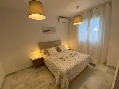 a bedroom with a bed with two candles on it at Apartamento en centro con garaje in Sanlúcar de Barrameda