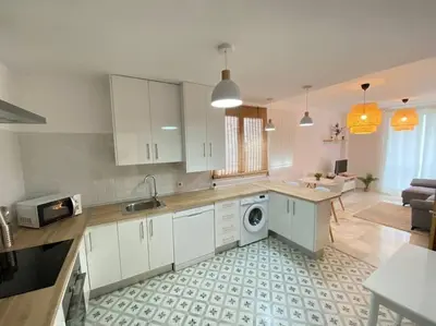 a kitchen with white cabinets and a washer at Apartamento en centro con garaje in Sanlúcar de Barrameda