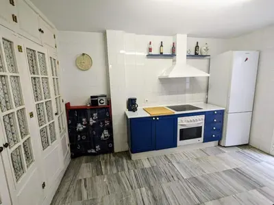 a kitchen with blue cabinets and a white refrigerator at Adosada en El Puerto Santa María in El Puerto de Santa María