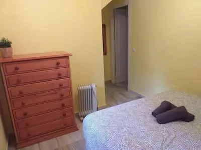 a bedroom with a dresser and a bed and a dresser at Adosada en El Puerto Santa María in El Puerto de Santa María