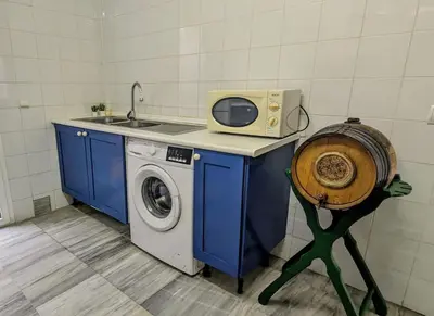 a kitchen with a washing machine and a microwave at Adosada en El Puerto Santa María in El Puerto de Santa María