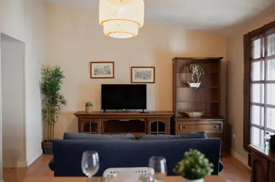 a living room with a blue couch and a tv at Apartamento El Catavino in Jerez de la Frontera