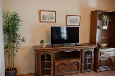 a flat screen tv on a wooden entertainment center at Apartamento El Catavino in Jerez de la Frontera