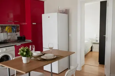 a kitchen with a table and a white refrigerator at Apartamento El Catavino in Jerez de la Frontera