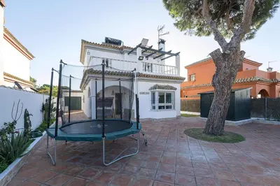 two chairs and an umbrella in a yard at Villa del Sol in Novo Sancti Petri