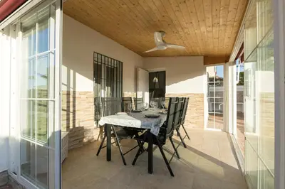a patio with a table and chairs on it at Villa del Sol in Novo Sancti Petri
