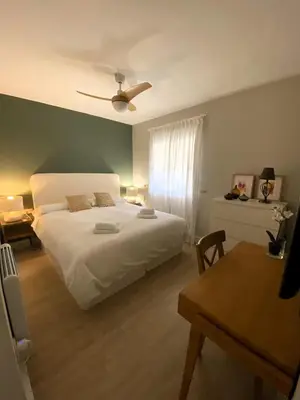 a bedroom with a white bed and a ceiling fan at Apartamento Buho Real - Vistahermosa in El Puerto de Santa María