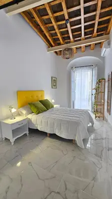 a bedroom with a large bed and a table at Don Roman Suites en pleno centro by Sanlúcar Housing in Sanlúcar de Barrameda