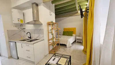 a kitchen with a sink and a bed in a room at Don Roman Suites en pleno centro by Sanlúcar Housing in Sanlúcar de Barrameda