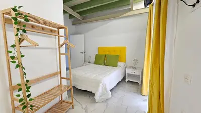 a small bedroom with a bed and a ladder at Don Roman Suites en pleno centro by Sanlúcar Housing in Sanlúcar de Barrameda
