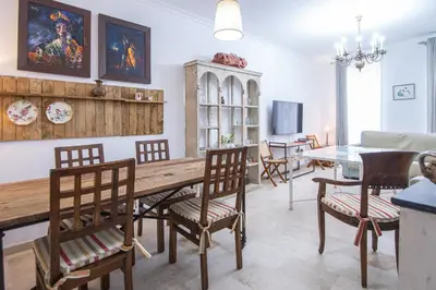 a living room with a wooden table and chairs at Apartamento El Paseo de la Alameda de Cádiz in Cádiz