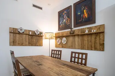 a dining room with a wooden table and chairs at Apartamento El Paseo de la Alameda de Cádiz in Cádiz