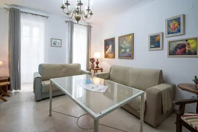 a living room with a glass table and chairs at Apartamento El Paseo de la Alameda de Cádiz in Cádiz