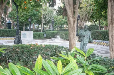 a statue of a man standing next to a tree at Apartamento El Paseo de la Alameda de Cádiz in Cádiz