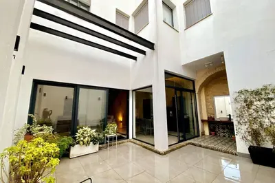 a large white building with windows and plants at Preciosa Casa Centro Histórico Jerez, Parking privado+ WI-FI in Jerez de la Frontera
